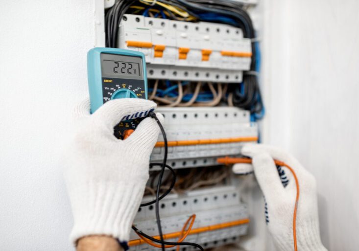 Electrician installing or repairing apartment electrical panel, close-up view